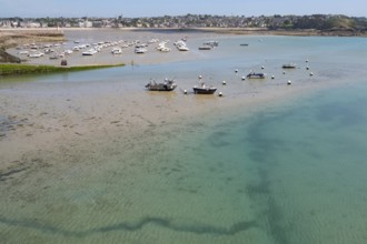 View of shallow turquoise water and moist sandy soil at low tide (low tide), with shadows of