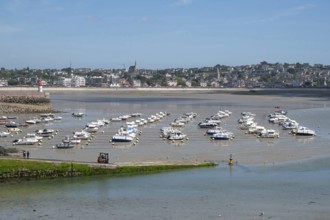 At low tide (low tide), a large collection of small motorboats lies neatly in rows on the moist
