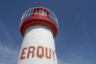An extreme bottom view shows the upper, cylindrical part of the white-red lighthouse of Erquy,