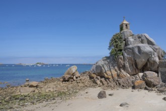 The small, historic Saint-Gildas chapel is perched on rugged, pink rock formations on the banks of