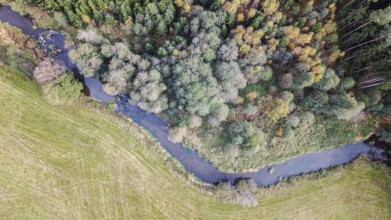 This scene shows a gently flowing river surrounded by colorful trees. The colors of autumn give the