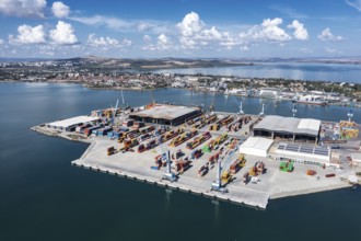 A busy port with shipping containers and cranes. Aerial view to new container unloading terminal of
