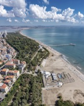 City beach with a long pier extending into the ocean. Aerial view to bech and sea garden of Burgas,