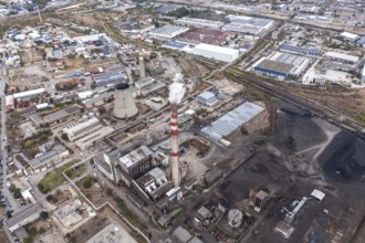 Factory complex with smokestacks amid an industrial urban setting. Aerial view of thermal power