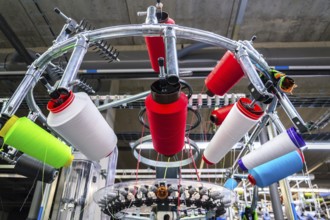 Colorful reel thread set up at modern and automatic sewing or embroidery spinning machine, textile