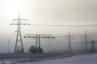 Electricity pylons from distribution power station in foggy winter freeze Prague Czech republic