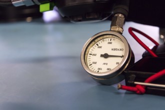 Gas pressure indicator, scuba diving oxygen lying on blue table background, copy space Prague Czech