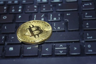Golden bitcoin coin lying on green computer keyboard, cryptocurrency investing concept Prague Czech