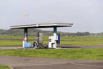 Aviation fuel filling station on airport with airfield runway in background on a sunny spring day