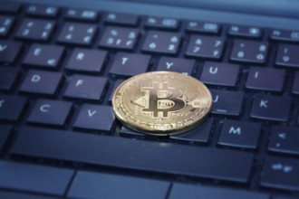 Golden bitcoin coin on computer keyboard, cryptocurrency bitcoin mining concept Prague Czech