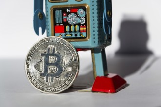 Vintage tin toy robot with bitcoin coin, cryptocurrency mining concept Prague Czech republic