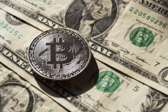 Silver bitcoin coin lying on United States dollars, cryptocurrency concept Prague Czech republic