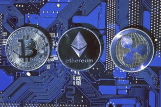 Bitcoin, Ethereum, Ripple coins on computer motherboard, cryptocurrency investing concept Prague,