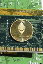 Golden ethereum coin lying on computer motherboard, cryptocurrency investing concept Prague, Czech