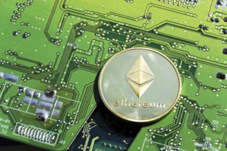 Golden Ethereum coin lying on computer motherboard, cryptocurrency investing, blockchain technology