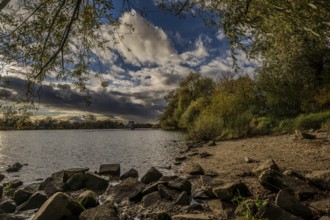 The quiet Danube in the background, surrounded by trees and rocks. The sky is covered with clouds.