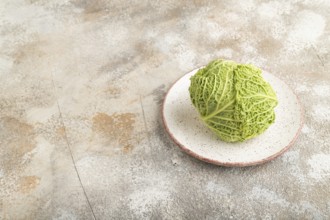 Green lettuce on plate on brown concrete background. Side view, copy space. healthy food,