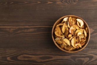 Dried Apples in wooden bowl on brown wooden background. Top view, copy space, flat lay. healthy