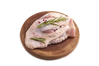 Raw Turkey Thigh with spices and rosemary on cutting board isolated on white background. side view,