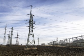 Electricity pylons with distribution power station blue cloudy sky background Prague Czech republic