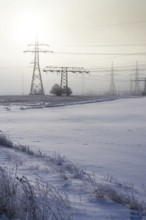 Electricity pylons from distribution power station in foggy winter freeze Prague Czech republic