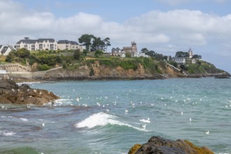 The rocky bay of the Plage de la Comtesse with a little wave wave in the turquoise water, which is