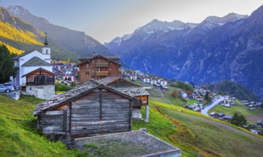 City overview on a mountain terrace above the valley with Ulrichshorn 3925 m after sunset, Grächen,