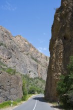 Asphalt road between high rock walls under clear sky, Amaghu Gorge from Noravank Monastery,