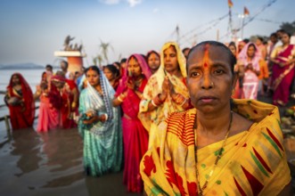 Hindu devotees offer prayers to the Sun God on the bank of Brahmaputra river on the occasion of