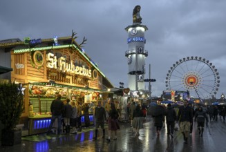 Oktoberfest visitors with umbrellas, rainy meadows, Löwenbräuturm, Ferris wheel, Munich, Bavaria,