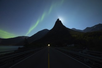 National mountain of Norway, Stetind in the Nordland under auroras and a full moon. On the road