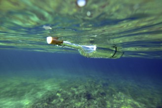 A bottle with a Message is floating under the surface of the mediterranean sea, majorca, balearics,