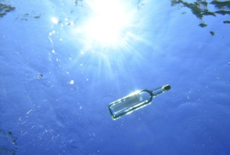 A bottle with a message is floating under the surface of the sea, Majorca, balearics, spain