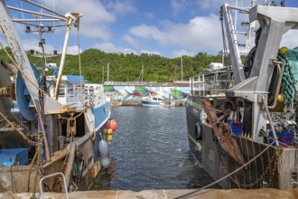 Two large, rusty fishing boats in the Port du Legue harbour at the mouth of the Legue. In the