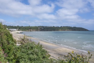 The sandy beach of Plage des Nouelles (Plerin) in the wide bay of Saint-Brieuc, surrounded by green