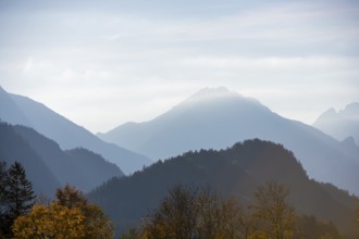 Blurred mountain peaks in the background and autumn leaves in the foreground, Schwangau, Ostallgäu,