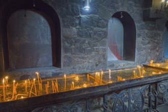 Candlelit room on the altar surrounded by dark stone walls and peaceful atmosphere, Khor Virap