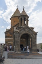 Church building with decorative entrance and dome, people enter the historic building, Khor Virap