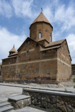 Historic stone church building with distinctive towers and a dome against a blue sky, Khor Virap