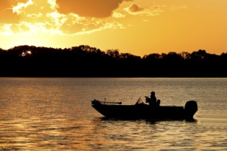 A boat on Lake Gudelack at sunset, Lindow (Mark), Stechlin-Ruppiner Land nature park Park,