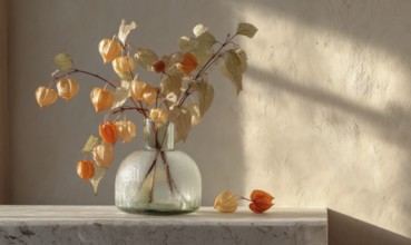 A vase of flowers sits on a table, with a few leaves scattered around it. The vase is filled with