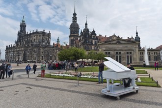 Dresden, Gerrmany- May 6, 2017: Musicians are playing on the sqare in the background Cathedral of