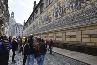 Dresden, Gerrmany- May 6, 2017: Tourist looking at the panel Procession of Princes the first of the