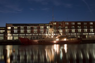 LUBECK, GERMANY - AUGUST 3, 2016: Ship in harbor during twilight. Lubeck is the 2nd largest city in
