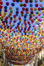 View of a street decorated with colored lanterns for the holidays, blue sky in the background