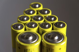 Stack of yellow AA batteries close up, electricity storage concept