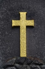 Golden Christian cross on stone background, tomb in the cemetery, life and death concept
