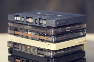 Filtered retro compact cassette audio magnetic tapes on wooden background