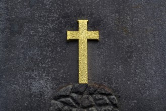 Golden Christian cross on stone background, tomb in the cemetery, life and death concept