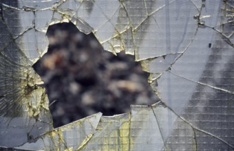 Filtered vintage photograph of hole in a broken security glass